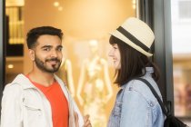 Couple souriant debout devant un magasin — Photo de stock