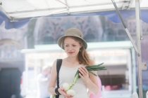 Жінка купує весняну цибулю на вуличному ринку — стокове фото