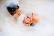 Молодая девушка играет в ванне с пеной — стоковое фото