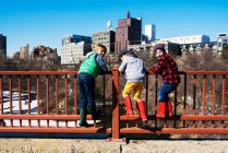 Трое детей, стоящих на мосту Стоун Арч, возятся с Миннеаполисом, Миннесота, Америка, США — стоковое фото