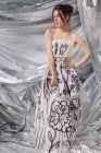 Woman wearing paper dress on glossy background — Stock Photo