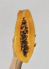 Donna mano che tiene un frutto di papaia — Foto stock