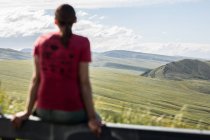 Donna seduta su una ringhiera guardando la vista, Lander, Wyoming, America, USA — Foto stock