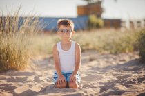 Портрет улыбающегося мальчика, сидящего на пляже, Болгария — стоковое фото