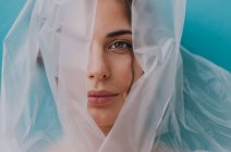 Portrait of a woman wrapped in transparent plastic — Stock Photo