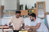 Двое мужчин готовят ужин вместе — стоковое фото