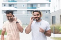 Due uomini che ascoltano musica sul cellulare — Foto stock