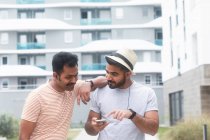 Dois homens ouvindo música em seu celular — Fotografia de Stock