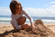 Девушка, сидящая на пляже, строит песчаный замок, Австралия — стоковое фото
