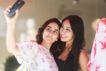 Zwei Frauen stehen in einem Geschäft und machen ein Selfie — Stockfoto