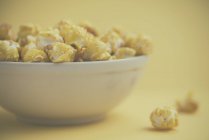 Weiße Schüssel mit leckerem Popcorn, Nahaufnahme — Stockfoto