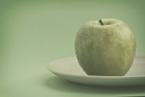 Vista de close-up de maçã verde em uma chapa — Fotografia de Stock