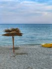 Мальовничий вид на шезлонгу, парасолька і човен на пляжі, Болгарія — стокове фото