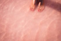 Primo piano dei piedi di una ragazza in acque poco profonde nell'oceano, Australia — Foto stock