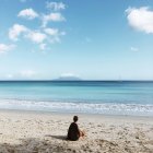 Вид сзади женщины, сидящей на пляже, Сейшелы — стоковое фото