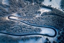 Vista aérea de la sinuosa carretera a través de las montañas en invierno, Salzburgo, Austria - foto de stock