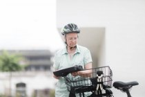 Woman replacing the battery on her e-bike — Stock Photo