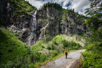 Woman hiking near waterfall, Sportgastein, Salzburg, Austria — Stock Photo