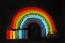 Mehrfarbige weiche Ölpastellkreiden und eine Regenbogenzeichnung — Stockfoto