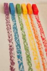Pastelli ad olio morbidi multicolori in fila su sfondo bianco — Foto stock