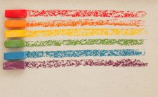 Pasteles al óleo suaves multicolores en una fila sobre fondo blanco - foto de stock