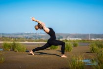 Femme sur la plage de Los Lances faisant guerrier je pose de yoga, Parc Naturel du Détroit, Tarifa, Cadix, Andalousie, Espagne — Photo de stock