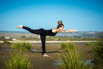 Donna sulla spiaggia di Los Lances facendo posa guerriero III yoga, Lo stretto Parco Naturale, Tarifa, Cadice, Andalusia, Spagna — Foto stock