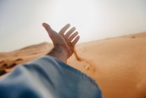 Sabbia che attraversa la mano di un uomo nel deserto, Marocco — Foto stock