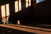 Мальчик в бассейне в тени — стоковое фото