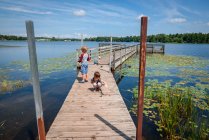 Three children fishing on a dock in the summer, United States — Stock Photo