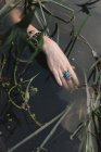 Женская рука с аксессуарами в озере, обрезанные — стоковое фото
