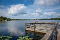 Boy standing on a dock fishing, United States — Stock Photo