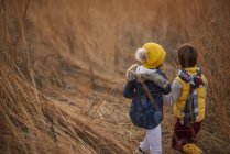 Menino e menina em pé em um campo, Estados Unidos — Fotografia de Stock