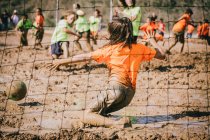 Дети играют в футбол в грязи — стоковое фото