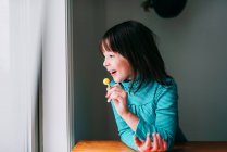 Ritratto di una ragazza sorridente con un lecca-lecca — Foto stock