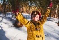 Mädchen steht im Wald und greift im Winter nach einem Ast — Stockfoto