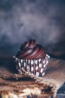 Шоколадный кекс на салфетке на деревенском фоне — стоковое фото