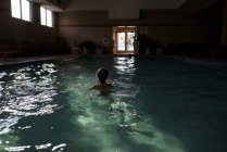Menino usando óculos de natação em uma piscina — Fotografia de Stock