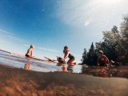 Três crianças navegando em um lago em uma jangada de madeira, Lake Superior, Estados Unidos — Fotografia de Stock