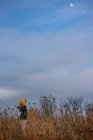Ragazza in piedi in un campo che punta verso la luna, Stati Uniti — Foto stock