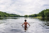 Rückansicht eines Jungen, der in einem See steht, Vereinigte Staaten — Stockfoto