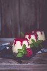 Três sobremesas de panna cotta com framboesa coulis, framboesa e hortelã — Fotografia de Stock
