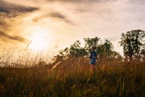 Portrait d'un garçon debout dans un champ au coucher du soleil, États-Unis — Photo de stock