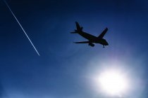 Силуэт летающего в небе самолета — стоковое фото