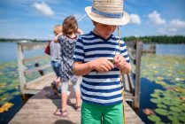 Троє дітей рибалять на причалі влітку (США). — стокове фото