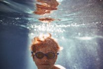 Крупним планом хлопчик плаває під водою в басейні — стокове фото