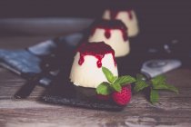 Drei Panna-Cotta-Desserts mit Himbeercoulis, Himbeere und Minze — Stockfoto