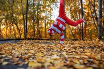 Мальчик прыгнул на трамплине, покрытом осенними листьями, США — стоковое фото