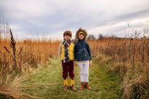 Porträt eines Jungen und eines Mädchens, die auf einem Feld stehen, USA — Stockfoto