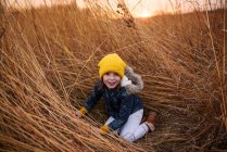 Ragazza sorridente che gioca in un campo al tramonto, Stati Uniti — Foto stock